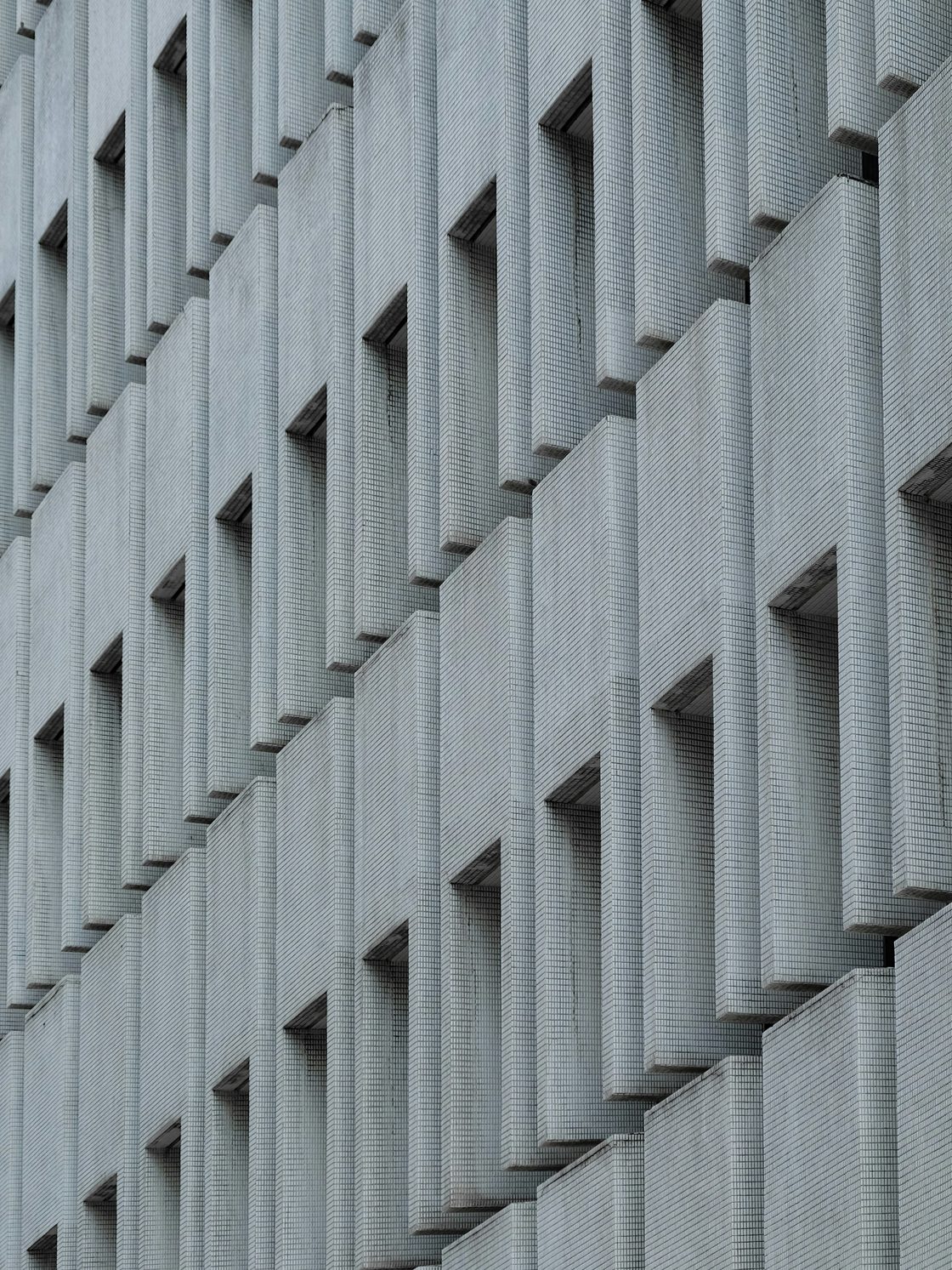White concrete facade with a repeating geometric window pattern